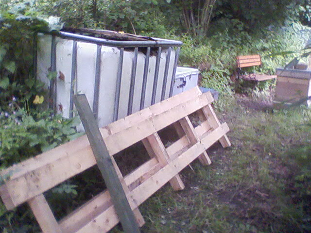 Fencing made from a palette to be installed behind the beehives. The IBC tank has now been moved to behind the garage.